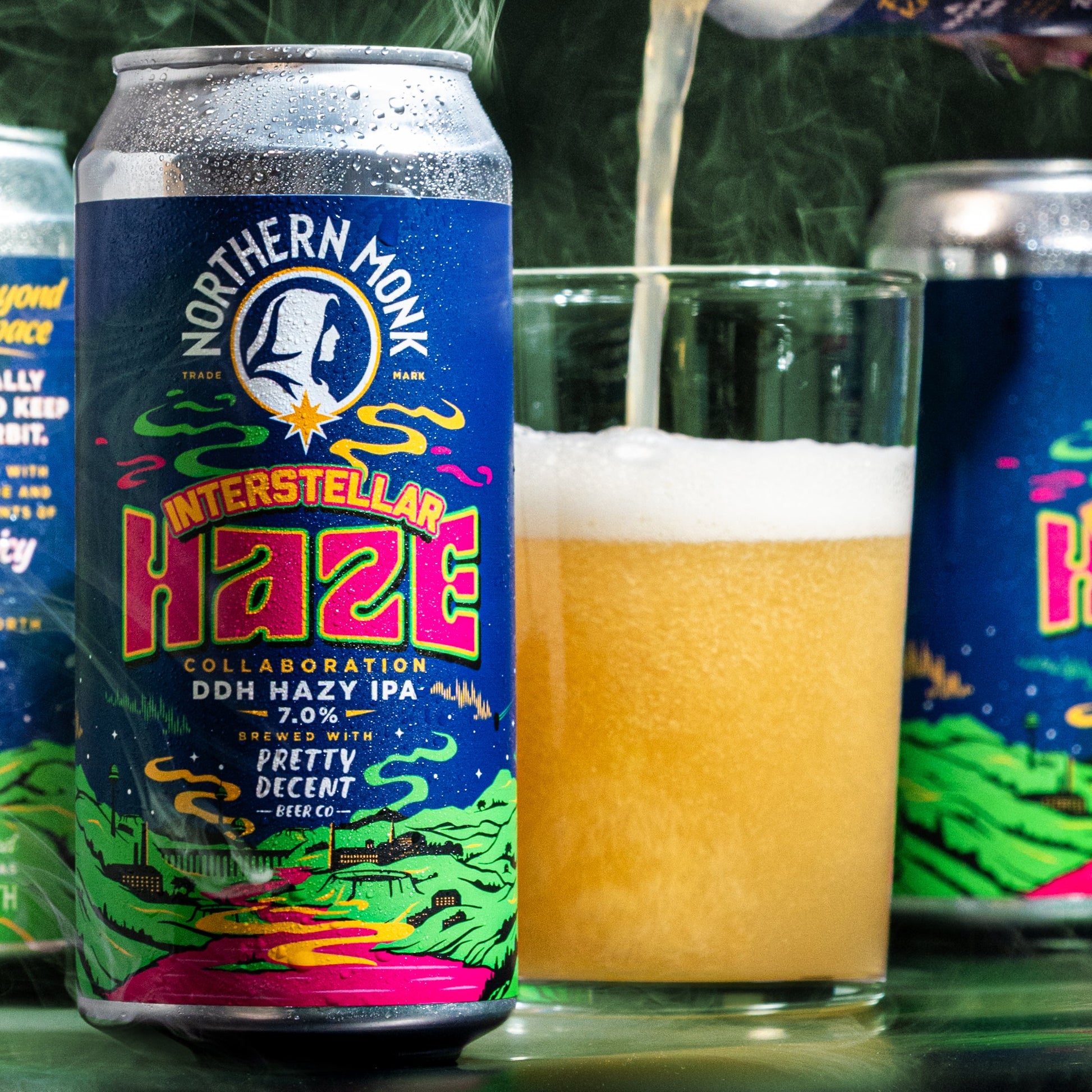 Can of Northern Monk Interstellar 
Haze IPA being poured into a glass with a green leafy background.